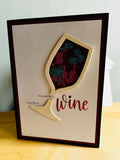 Handmade shaker birthday card front with a shimmering wine-glass window filled with glittery wine-glass confetti and the words Birthdays are a good time to wine